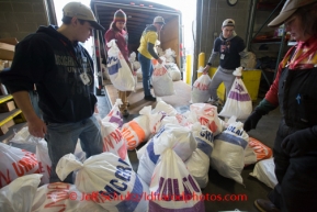 At the Airland Transport's sort facility, volunteers sort, weigh and tag musher food drop bags that are headed out for the 20+ checkpoints on Wednesday February 12, 2014.  PHOTO BY JEFF SCHULTZ/IDITARODPHOTOS.COM  USE ONLY WITH PERMISSION