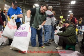 At the Airland Transport's sort facility, volunteers sort, weigh and tag musher food drop bags that are headed out for the 20+ checkpoints on Wednesday February 12, 2014.  PHOTO BY JEFF SCHULTZ/IDITARODPHOTOS.COM  USE ONLY WITH PERMISSION