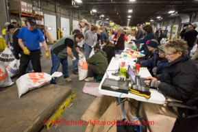 At the Airland Transport's sort facility, volunteers sort, weigh and tag musher food drop bags that are headed out for the 20+ checkpoints on Wednesday February 12, 2014.  PHOTO BY JEFF SCHULTZ/IDITARODPHOTOS.COM  USE ONLY WITH PERMISSION