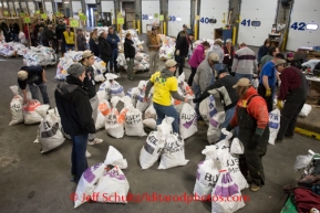 At the Airland Transport's sort facility, volunteers sort, weigh and tag musher food drop bags that are headed out for the 20+ checkpoints on Wednesday February 12, 2014.  PHOTO BY JEFF SCHULTZ/IDITARODPHOTOS.COM  USE ONLY WITH PERMISSION