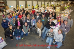 At the Airland Transport's sort facility, volunteers pose for a group photo.  These volunteers were on hand to sort, weigh and tag musher food drop bags that are headed out for the 20+ checkpoints on Wednesday February 12, 2014.  PHOTO BY JEFF SCHULTZ/IDITARODPHOTOS.COM  USE ONLY WITH PERMISSION