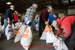 At the Airland Transport's sort facility, volunteers sort, weigh and tag musher food drop bags that are headed out for the 20+ checkpoints on Wednesday February 12, 2014.  PHOTO BY JEFF SCHULTZ/IDITARODPHOTOS.COM  USE ONLY WITH PERMISSION