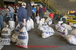 At the Airland Transport's sort facility, volunteers sort, weigh and tag musher food drop bags that are headed out for the 20+ checkpoints on Wednesday February 12, 2014.  PHOTO BY JEFF SCHULTZ/IDITARODPHOTOS.COM  USE ONLY WITH PERMISSION