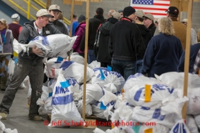 At the Airland Transport's sort facility, volunteers sort, weigh and tag musher food drop bags that are headed out for the 20+ checkpoints on Wednesday February 12, 2014.  PHOTO BY JEFF SCHULTZ/IDITARODPHOTOS.COM  USE ONLY WITH PERMISSION