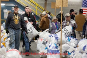 At the Airland Transport's sort facility, volunteers sort, weigh and tag musher food drop bags that are headed out for the 20+ checkpoints on Wednesday February 12, 2014.  PHOTO BY JEFF SCHULTZ/IDITARODPHOTOS.COM  USE ONLY WITH PERMISSION