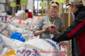 Volunteer Linda Gorum calculates weight at the Airland Transport's sort facility as volunteers sort, weigh and tag musher food drop bags that are headed out for the 20+ checkpoints on Wednesday February 12, 2014.  PHOTO BY JEFF SCHULTZ/IDITARODPHOTOS.COM  USE ONLY WITH PERMISSION