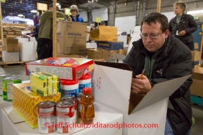 At the Airland Transport's sort facility volunteer Chris Blankenship sorts and package people food & accompanying supplies for the trail volunteers to eat during the race at the 20+ checkpoints on Friday February 14, 2014.  Iditarod Sled Dog Race 2014PHOTO BY JEFF SCHULTZ/IDITARODPHOTOS.COM  USE ONLY WITH PERMISSION