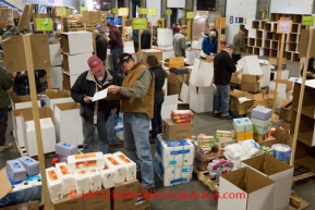 At the Airland Transport's sort facility, volunteers sort and package people food & accompanying supplies for the trail volunteers to eat during the race at the 20+ checkpoints on Friday February 14, 2014.  Iditarod Sled Dog Race 2014PHOTO BY JEFF SCHULTZ/IDITARODPHOTOS.COM  USE ONLY WITH PERMISSION