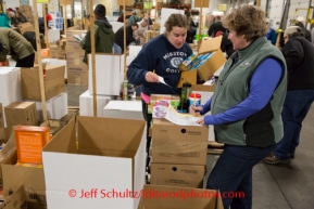 At the Airland Transport's sort facility, volunteers sort and package people food & accompanying supplies for the trail volunteers to eat during the race at the 20+ checkpoints on Friday February 14, 2014.  Iditarod Sled Dog Race 2014PHOTO BY JEFF SCHULTZ/IDITARODPHOTOS.COM  USE ONLY WITH PERMISSION