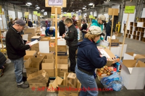 At the Airland Transport's sort facility, volunteers sort and package people food & accompanying supplies for the trail volunteers to eat during the race at the 20+ checkpoints on Friday February 14, 2014.  Iditarod Sled Dog Race 2014PHOTO BY JEFF SCHULTZ/IDITARODPHOTOS.COM  USE ONLY WITH PERMISSION