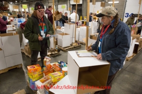 At the Airland Transport's sort facility, volunteers sort and package people food & accompanying supplies for the trail volunteers to eat during the race at the 20+ checkpoints on Friday February 14, 2014.  Iditarod Sled Dog Race 2014PHOTO BY JEFF SCHULTZ/IDITARODPHOTOS.COM  USE ONLY WITH PERMISSION