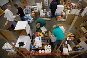 At the Airland Transport's sort facility, volunteers sort and package people food & accompanying supplies for the trail volunteers to eat during the race at the 20+ checkpoints on Friday February 14, 2014.  Iditarod Sled Dog Race 2014PHOTO BY JEFF SCHULTZ/IDITARODPHOTOS.COM  USE ONLY WITH PERMISSION