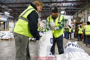 Iditarod volunteers Pam Jacobs and Elder Moala organize and stack the mushers food bags destined for the checkpoints on the 2017 Iditarod at the Airland Transport warehouse facilities in Anchorage Alaska.