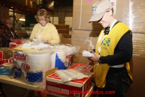 Friday, February 15, 2013.   Volunteers Pat Hanson (L) and Sister Marissa Hedelius (from the LDS church Helping Hands Ministry) count forks to be sent out to the 22 checkpoints along the Iditarod trail at Airland Transport in Anchorage.