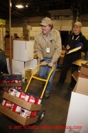 Friday, February 15, 2013.   Volunteer Sean Porter wheels cans of hot chocholate through the isles as Pat Hensmanns  keeps track of what checkpoints they go to during the