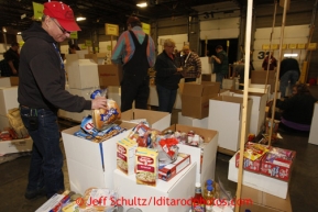 Friday, February 15, 2013.   Volunteer Jerry Trotten puts one of the 144 bags of hot dog buns into a box of other food to be sent to Nome during the