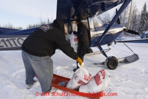 February 16, 2013  Volunteer Larry Cheeso helps Iditarod Air Force pilot Bill Mayer  load his Cessna at the Willow airport as musher food, straw, HEET and people food is flown to the 4 checkpoints on the east side the Alaska Range. Iditarod 2013 Photo Copyright Jeff Schultz  -- Do not reproduce without written permission