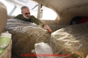 February 16, 2013  Volunteer Iditarod Air Force pilot Greg Miller loads his Cessan with Hay and musher food bags at the Willow airport as musher food, straw, HEET and people food is flown to the 4 checkpoints on the east side the Alaska Range. Iditarod 2013 Photo Copyright Jeff Schultz  -- Do not reproduce without written permission