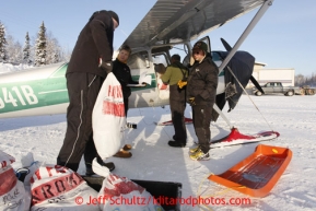 February 16, 2013  Logistics volunteers (L to R) Jason Spindler, Leslie Washburn and Chris Blankenship help load volunteer Iditarod Air Force pilot Greg Miller's plane at the Willow airport as musher food, straw, HEET and people food is flown to the 4 checkpoints on the east side the Alaska Range. Iditarod 2013 Photo Copyright Jeff Schultz  -- Do not reproduce without written permission