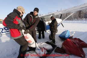 February 16, 2013  Logistics volunteers (L to R) Al Kiefer, Jason Spindler and Chris Blankenship help load volunteer Iditarod Air Force pilot Mike Swalling's plane at the Willow airport as musher food, straw, HEET and people food is flown to the 4 checkpoints on the east side the Alaska Range. Iditarod 2013 Photo Copyright Jeff Schultz  -- Do not reproduce without written permission