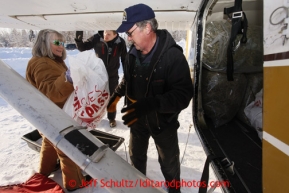 February 16, 2013  Volunteer Andi Malard helps Iditarod Air Force pilot Glen Hanson load his plane at the Willow airport as musher food, straw, HEET and people food is flown to the 4 checkpoints on the east side the Alaska Range. Photo Copyright Jeff Schultz  -- Do not reproduce without written permission