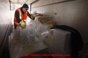 February 16, 2013  Volunteer  Chris Burns unloads musher's food bags from a van at the Willow airport on the first day of the