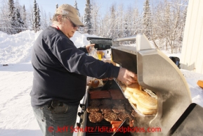 February 16, 2013  A volunteer since 1986, Larry Cheeso cooks hot dogs and burgers outdoors for pilots and other volunteers at the Willow airport on the first day of the