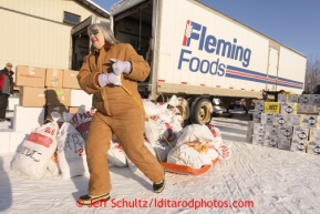 February 16, 2013  Volunteer Andi Malard helps unload  musher food bags bound for the Rainy Pass checkpoint from a van and stack them to be loaded into volunteer Iditarod Air Force planes at the Willow Airport during day one of the