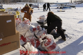 February 16, 2013  Volunteers Andi Malard (L) and Jennifer Ambrose stack musher food bags bound for Rainy Pass while other volunteers move supplies to waiting planes at the Willow airport as musher food, straw, HEET and people food is flown to the 4 checkpoints on the east side the Alaska Range. Photo Copyright Jeff Schultz  -- Do not reproduce without written permission