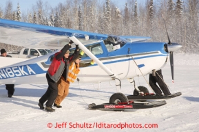 February 16, 2013  Volunteers help turn Greg Fischer's Cessna around at the Willow airport as musher food, straw, HEET and people food is flown to the 4 checkpoints on the east side the Alaska Range. Photo Copyright Jeff Schultz  -- Do not reproduce without written permission