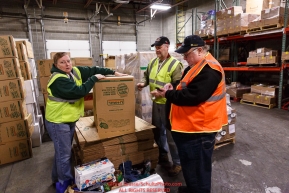 Iditarod volunteers Dan Paige and Pam Jacobs sort and repackage human food and supplies for the trail volunteers to eat and use at each of the checkpoints on the 2018 Iditarod. The sorting is going on at the Airland Transport warehouse facilities in Anchorage Alaska on Friday  February 19, 2017.