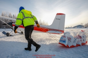 Volunteer pilot Russ Dunlap moves musher food bags toward a plane as the Iditarod Air Force flies out food and supplies to checkpoints on Saturday February 17th before the 2018 race from the Willow airport in Willow, Alaska Photo by Judy Patrick/SchultzPhoto.com  (C) 2018  ALL RIGHTS RESERVED