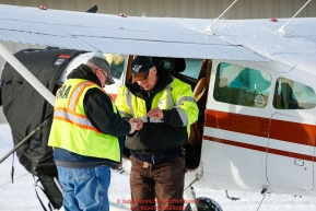 An FAA inspector checks over pilot Monte Mabry's paperwork as the Iditarod Air Force flies out  food and supplies to checkpoints before the 2018 race from the Willow airport in Willow, Alaska Photo by Judy Patrick/SchultzPhoto.com  (C) 2018  ALL RIGHTS RESERVED