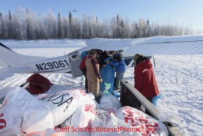 Saturday February 18, 2012   Volunteers load Mike Swalling's Cessna 206 at the Willow airport as another ITC plane takes off in the background.  Straw, musher food bags, lathe, people food and supplies begin to be flown out by the Iditarod volunteer Air Force  to checkpoints along the trail.