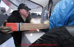 Saturday February 18, 2012   Volunteer pilot John Norris loads his plane with a bundle of lathe at the Willow airport as the straw, musher food bags, lathe, people food and supplies begin to be flown out by the Iditarod volunteer Air Force  to checkpoints along the trail.