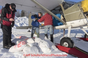 Saturday February 18, 2012  Volunteer Al Kiefer (L) calculates weight as Chris Blankenship (middle) helps pilot Ken Moon load his plane at the Willow airport as the straw, musher food bags, lathe, people food and supplies begin to be flown out by the Iditarod volunteer Air Force  to checkpoints along the trail.