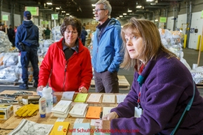 Volunteers Jennifer Dowliing (R) and Sherry Murphy (L) put weight measurements on postage tags bound for a slew of musher food bags as a team of volunteers unload, sort, weigh, tag and palletize thousands of musher food drop bags at Airland Transport warehouse in Anchorage on Wednesday February 18th prior to Iditarod 2015.(C) Jeff Schultz/SchultzPhoto.com - ALL RIGHTS RESERVEDDUPLICATION PROHIBITED WITHOUT PERMISSION