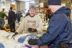 Long-time volunteer Wendy Walters helsp a member of the Alaska Military Youth Academy stack musher food drop bags at Airland Transport warehouse in Anchorage on Wednesday February 18th prior to Iditarod 2015.(C) Jeff Schultz/SchultzPhoto.com - ALL RIGHTS RESERVEDDUPLICATION PROHIBITED WITHOUT PERMISSION