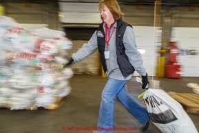 Longtime volunteer Teri Paton moves a musher's food drop bag to a pallet at Airland Transport warehouse in Anchorage on Wednesday February 18th prior to Iditarod 2015.(C) Jeff Schultz/SchultzPhoto.com - ALL RIGHTS RESERVEDDUPLICATION PROHIBITED WITHOUT PERMISSION