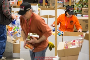 Volunteers sort and pack human food for the volunteers which will be working at the 20+ checkpoints durinig this year's 2016 Iditarod Race at the Airland Transport warehouse in Anchorage on Friday, February 19, 2016.