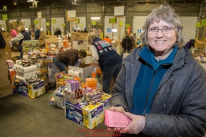 Longtime volunteer coordinator of the Iditarod People Food, Pat Owens, overseas the group of volunteers as they  sort and pack human food for the volunteers which will be working at the 20+ checkpoints durinig this year's 2016 Iditarod Race at the Airland Transport warehouse in Anchorage on Friday, February 19, 2016.