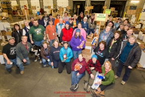 Volunteers take a break from sorting and packing human food to take a group photo at the Airland Transport warehouse in Anchorage on Friday, February 19, 2016 prior to the Iditarod 2016 race.