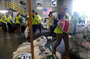 Iditarod volunteers sort musher food drop bags for the 2020 Iditarod Trail Sled Dog Race at Aril Land Transport in Anchorage, AK on Wednesday, February 19, 2020. The bags with food and equipment will be shipped to Iditarod checkpoints along the trail. (Photo by Bob Hallinen)