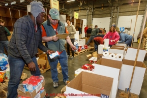Musher-turned volunteer, Newton Marshall (L) and volunteer Chris Blankenship determine how many coffee creamers they need put on a pallet headed to a particular checkpont.  Volunteers sort, stack and box