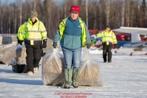 Volunteer Iditarod Air Force pilots, Diana Moroney and Greg Niesen move straw to waitng Iditarod Air Force planes at the Willow, Alaska airport during the Food Flyout on Saturday, February 20, 2016.  Iditarod 2016