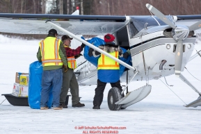 A group of volunteers help load straw into an Iditarod Air Force plane at the Willow, Alaska airport during the Food Flyout on Saturday, February 20, 2016.  Iditarod 2016