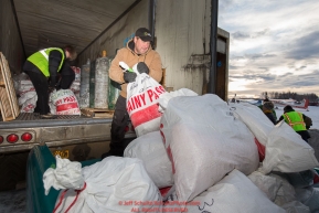 Volunteers move and sort straw, musher drop bags, people food and HEET to waitng Iditarod Air Force planes at the Willow, Alaska airport during the Food Flyout on Saturday, February 20, 2016.  Iditarod 2016