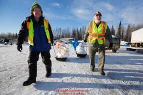 Volunteers move musher drop bags to waitng Iditarod Air Force planes at the Willow, Alaska airport during the Food Flyout on Saturday, February 20, 2016.  Iditarod 2016