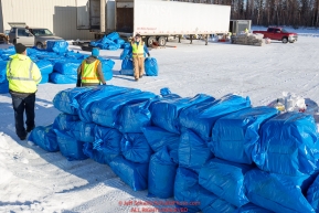 Volunteers stack bales of straw to stage them for the Iditarod Air Force planes at the Willow, Alaska airport during the Food Flyout on Saturday, February 20, 2016.  Iditarod 2016