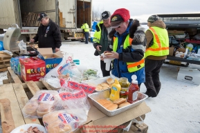 Volunteers take a short break to eat lunch at the Willow, Alaska airport during the Food Flyout on Saturday, February 20, 2016.  Iditarod 2016